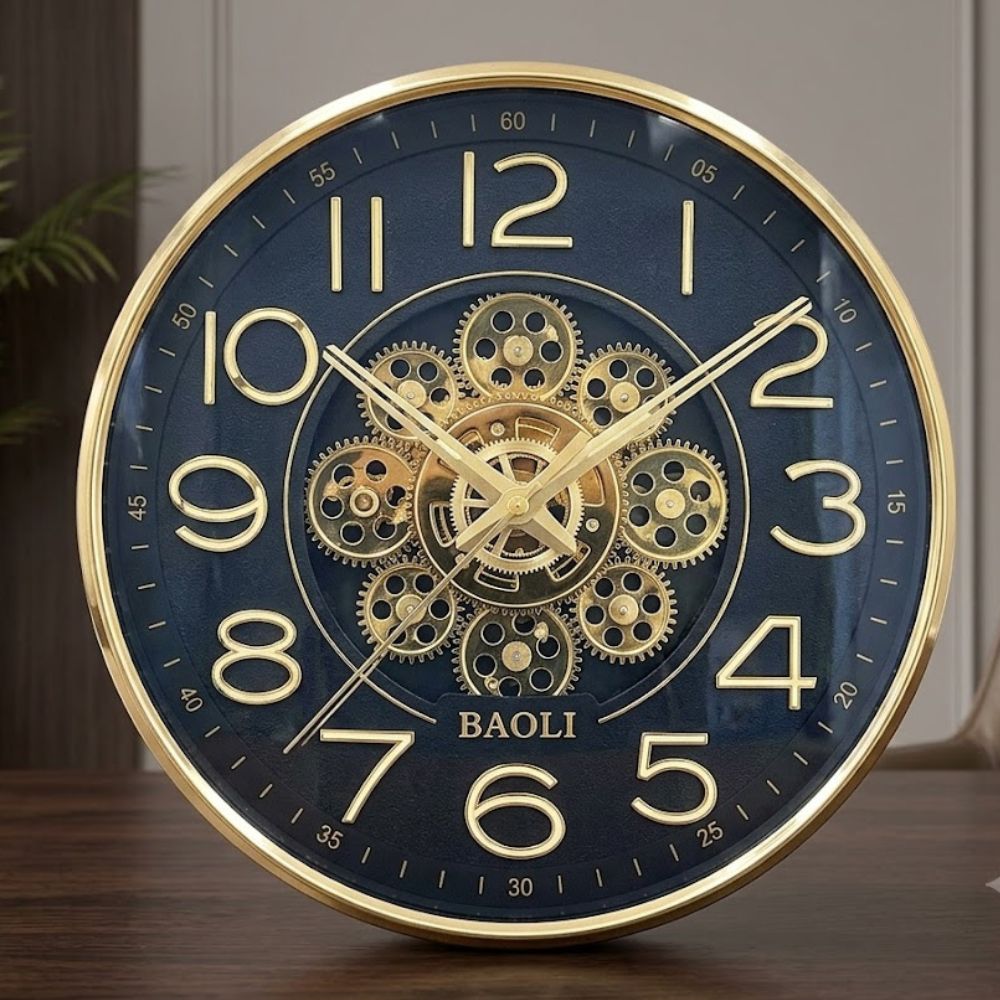 Round black wall clock featuring a polished gold rim, golden numbers, and intricate gold mechanical gears in the center.