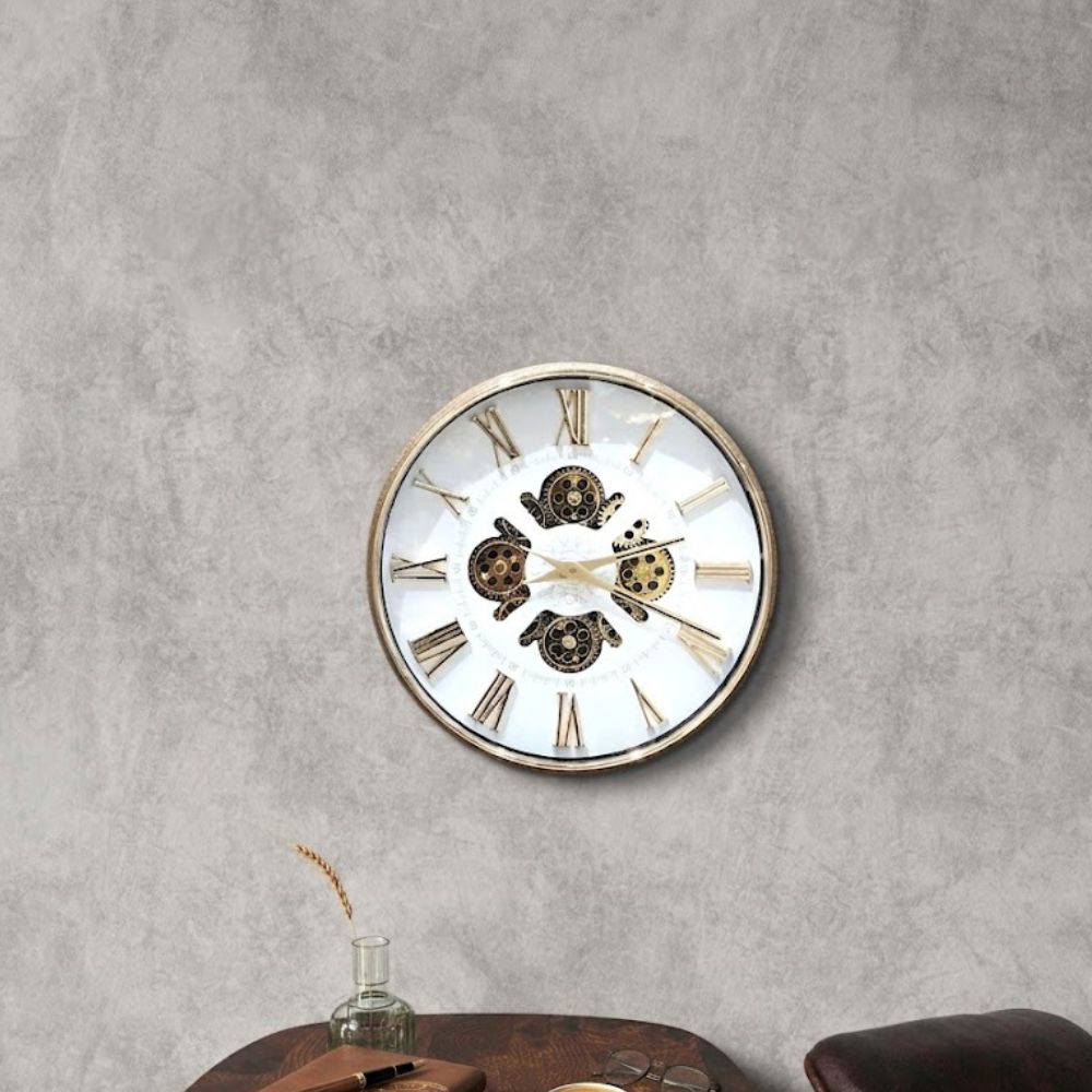 Round wall clock featuring a white dial, golden Roman numerals, and visible central vintage gears.
