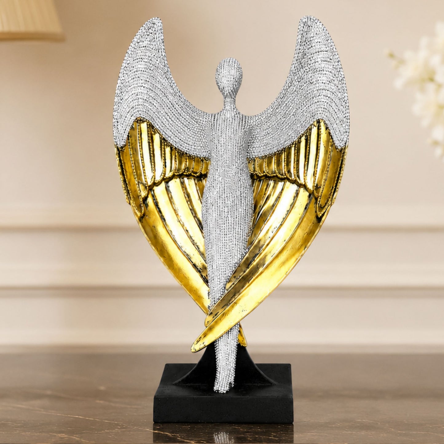 Textured silver standing angel figure with wide gold and silver wings on a black pedestal base.