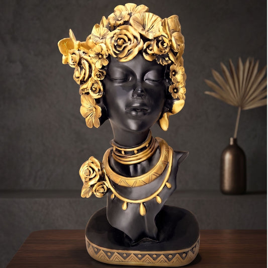 Matte black resin bust sculpture of a serene woman with detailed golden flowers and gold necklace accents.
