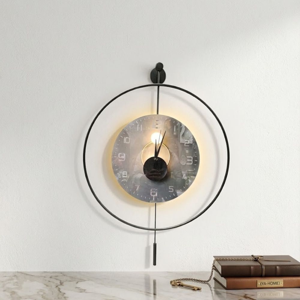 Minimalist round black metal frame wall clock with a glowing LED warm backlit dial and slim vertical pendulum.