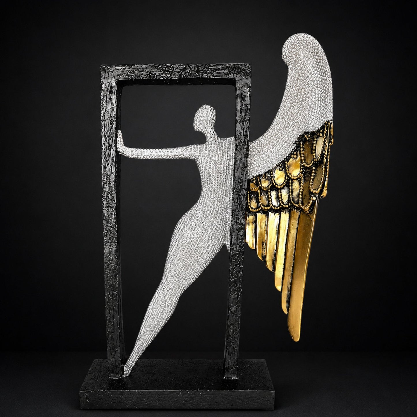 Modern abstract silver textured angel figure with gold wings posing inside a black frame for home table decor.