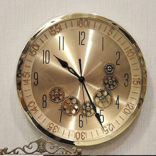 Round metallic wall clock with brushed brass finish and visible vintage gears on the dial.-1