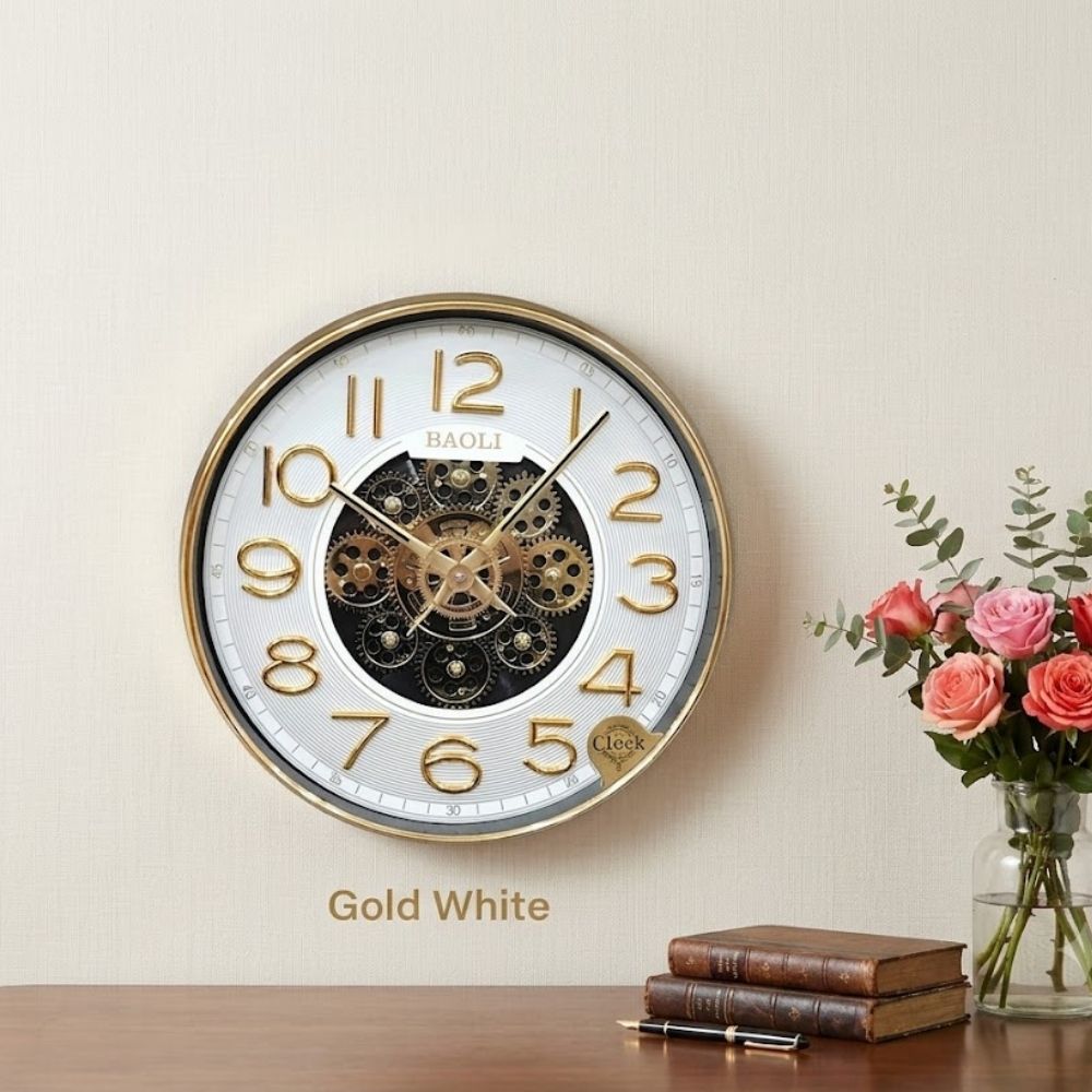 Round wall clock with a textured white outer ring, bold golden numbers, a golden metallic rim, and visible central gears.