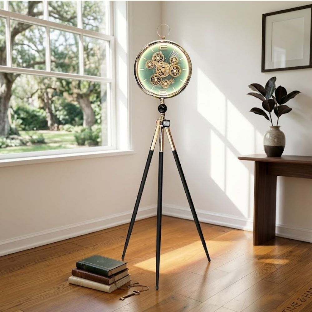 Standing tripod floor clock with black-gold legs and visible gears on a glowing green dial.