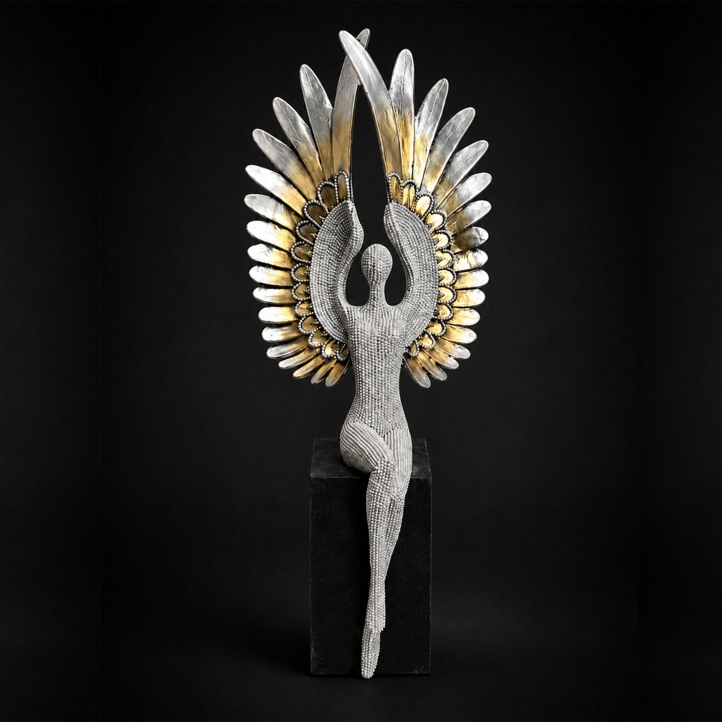 Textured silver seated angel figure with large gold and silver feathered wings perched on a black pedestal base.